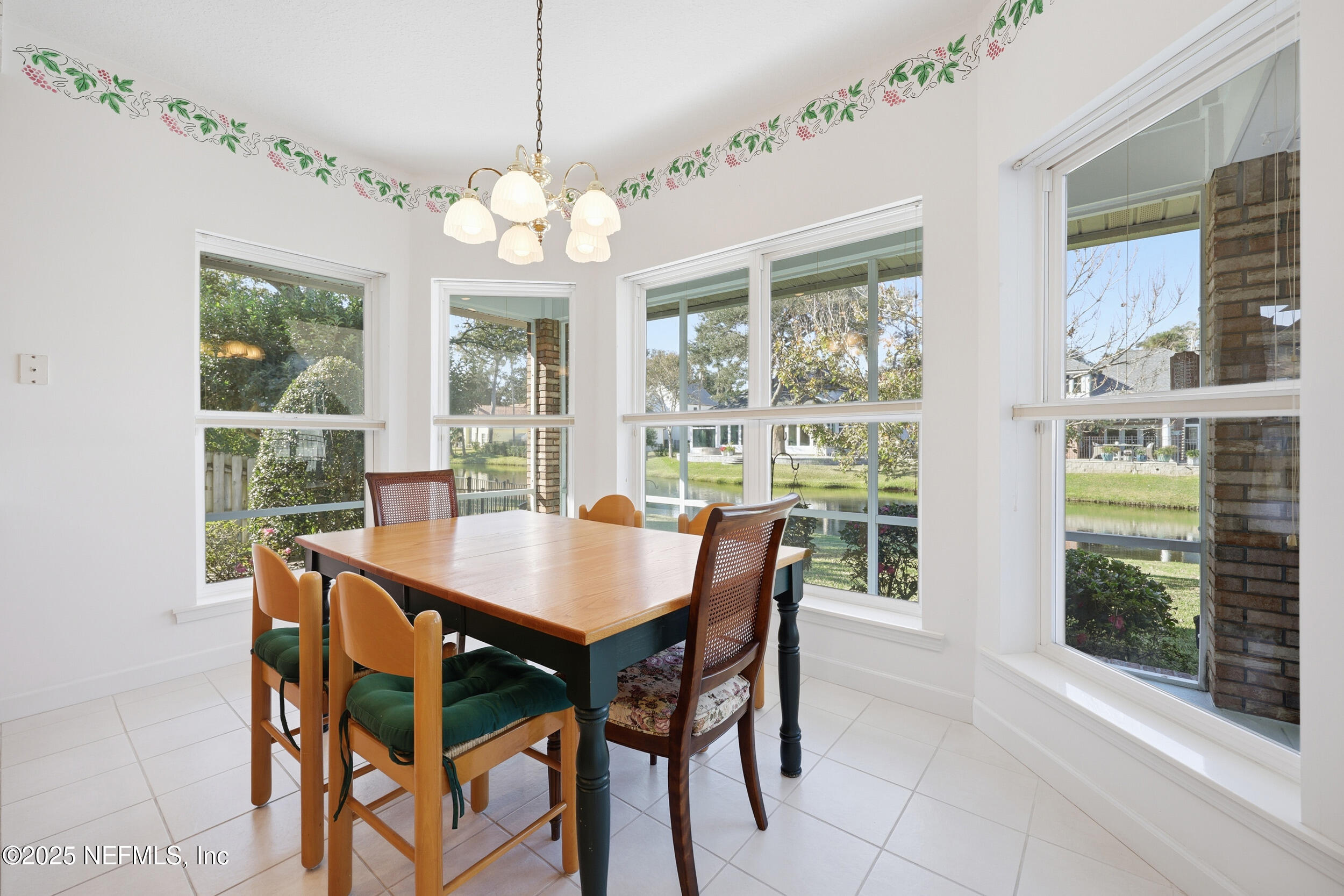 2332 Fiddlers Lane Atlantic Beach, FL 32233 - Photo 22 of 56 a dining room with wooden floor a chandelier a wooden table and chairs