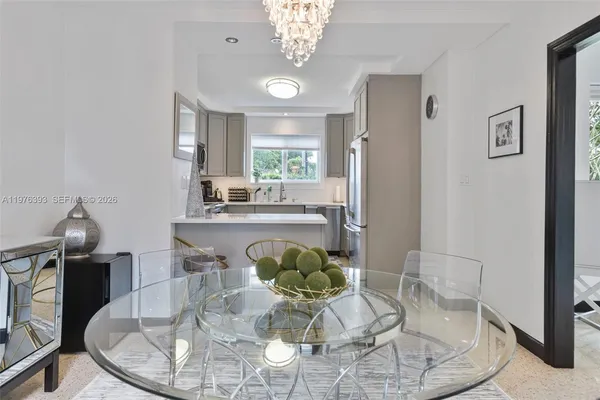 a dining room with furniture a chandelier and wooden floor