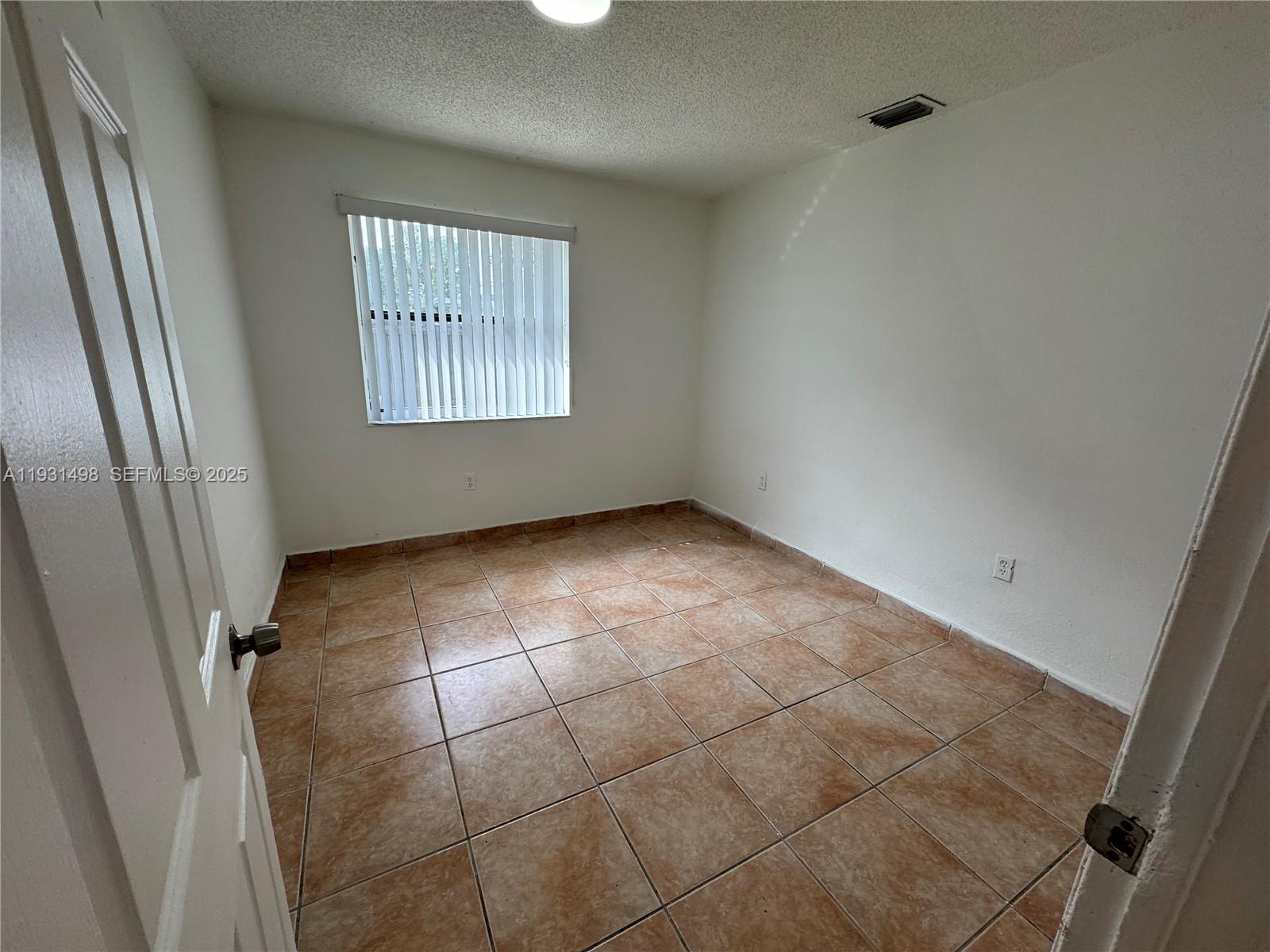 2146 Northwest 18th Terrace, Unit B Miami, FL 33125 - Photo 5 of 19 a view of an empty room with a window