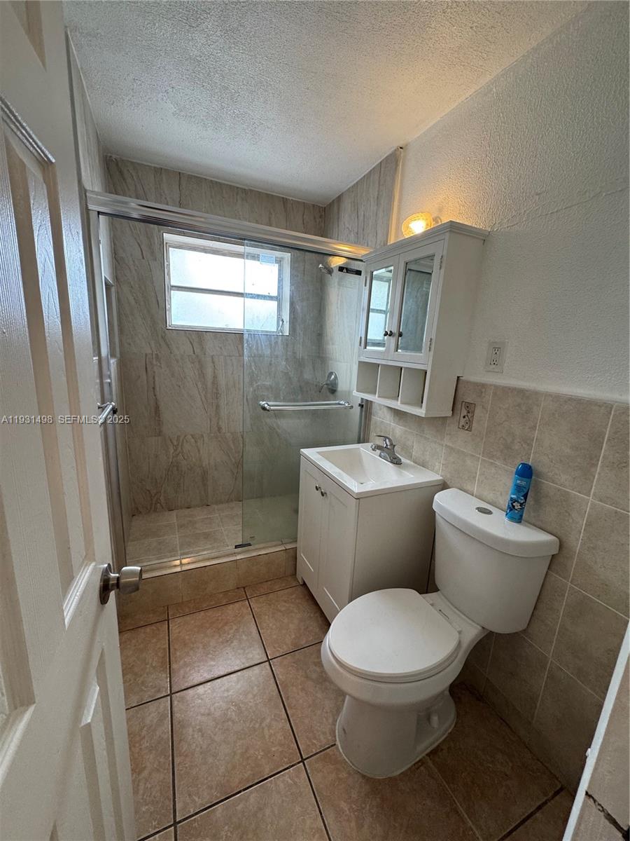 2146 Northwest 18th Terrace, Unit B Miami, FL 33125 - Photo 9 of 19 a bathroom with a toilet a sink and shower