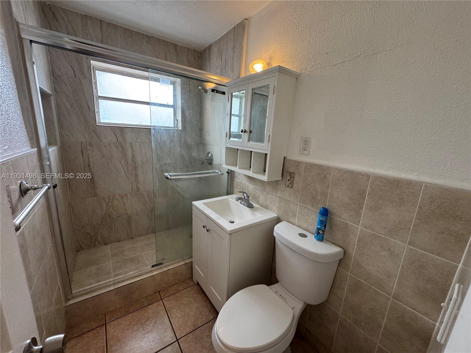 2146 Northwest 18th Terrace, Unit B Miami, FL 33125 - Photo 10 of 19 a white toilet sitting next to a bathroom sink
