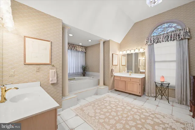 a spacious bedroom with a bed a ceiling fan and a dresser