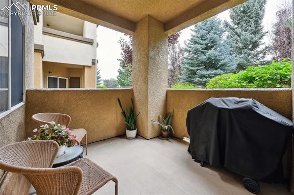a balcony with couple of chairs and a window