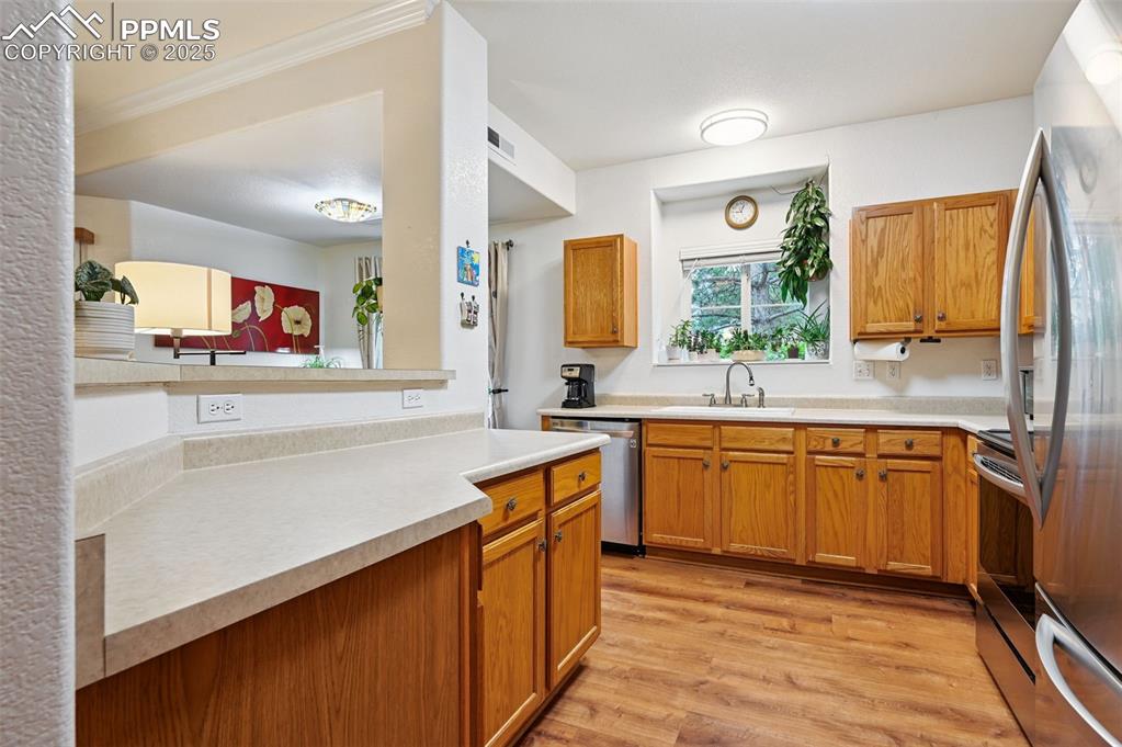 4007 Riviera Grove, Unit 103 Colorado Springs, CO 80922 - Photo 7 of 22 a kitchen with stainless steel appliances granite countertop sink stove and refrigerator