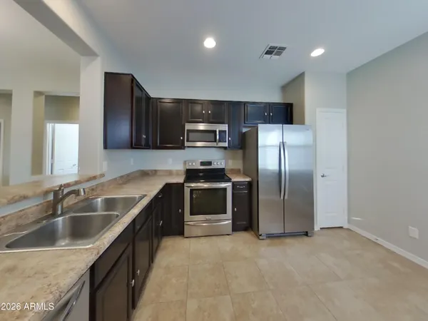 an empty room with wooden floor and chandelier