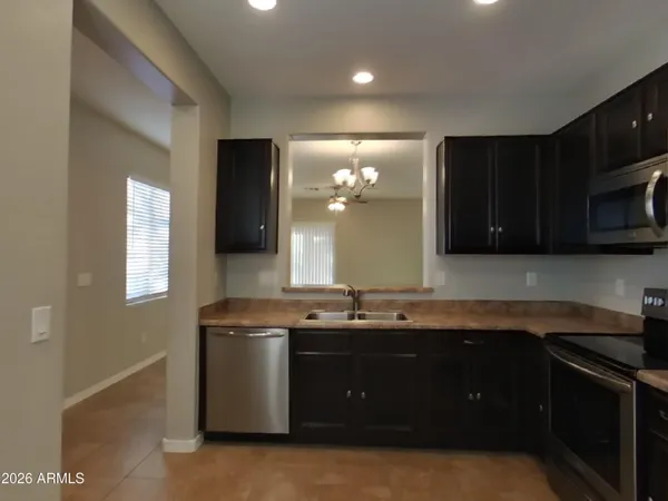 a kitchen with stainless steel appliances granite countertop a refrigerator a sink a stove a microwave and island