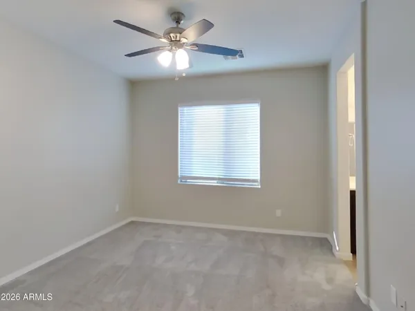 a view of an empty room and a ceiling fan