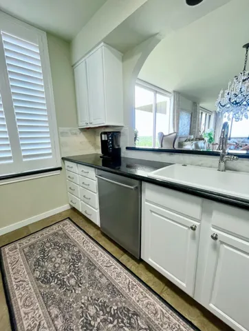 a kitchen with granite countertop a sink and cabinets