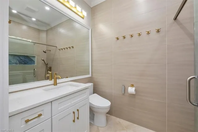 a bathroom with a granite countertop sink a toilet and shower