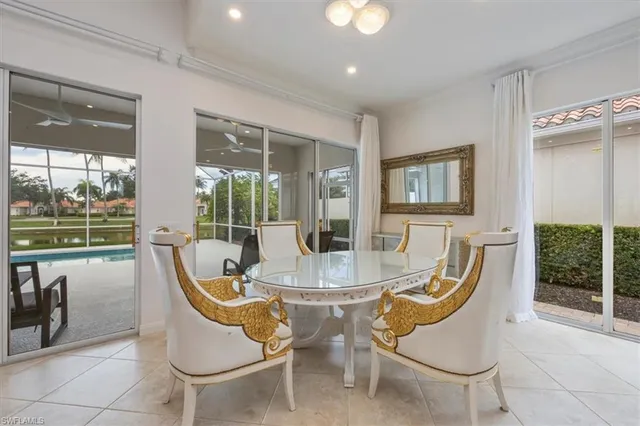 a dining room with furniture a chandelier and glass door