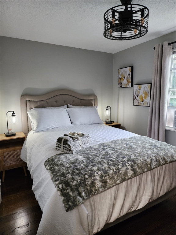 99 Cluff Crossing Road, Unit B12 Salem, NH 03079 - Photo 2 of 12 a bedroom with a bed and a chandelier