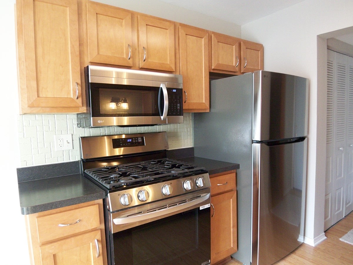 249 Nantucket Harbor Schaumburg, IL 60193 - Photo 12 of 26 a kitchen with granite countertop a refrigerator stove and microwave