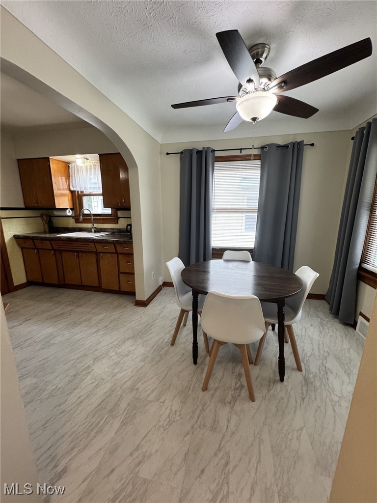 3712 Snow Road Cleveland, OH 44134 - Photo 8 of 40 Dining area featuring arched walkways, a textured ceiling, and a ceiling fan