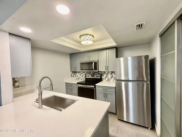 a kitchen with granite countertop a refrigerator and a sink