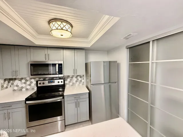 a kitchen with a refrigerator and a stove top oven