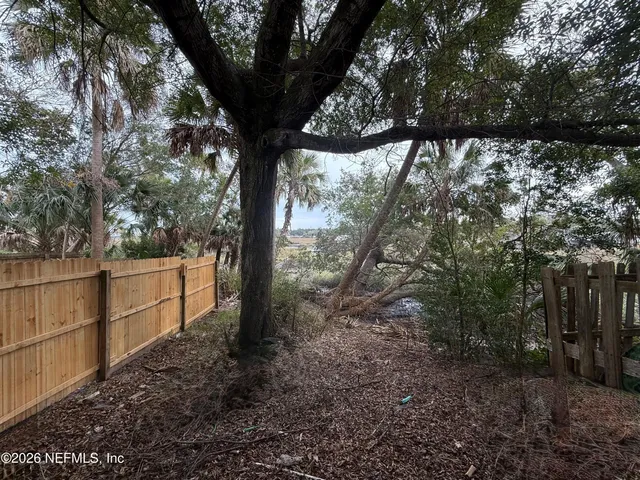 a view of a yard with large trees