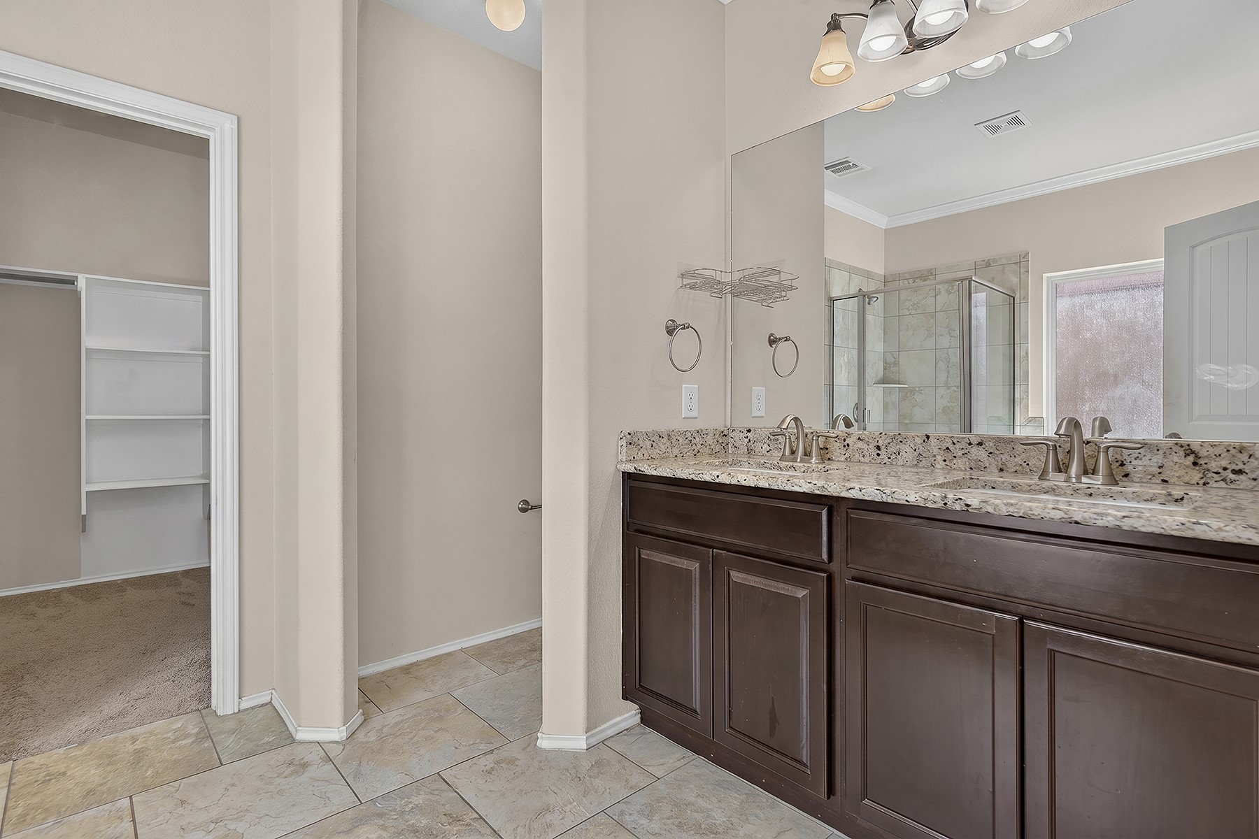 4601 Chestnut Meadows Bend Georgetown, TX 78626 - Photo 17 of 35 Double vanity with granite counters and rich cabinetry elevate this well-appointed primary bathroom.