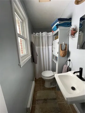 a bathroom with a toilet sink and mirror
