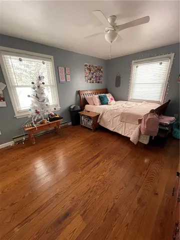 a spacious bedroom with a bed and wooden floor