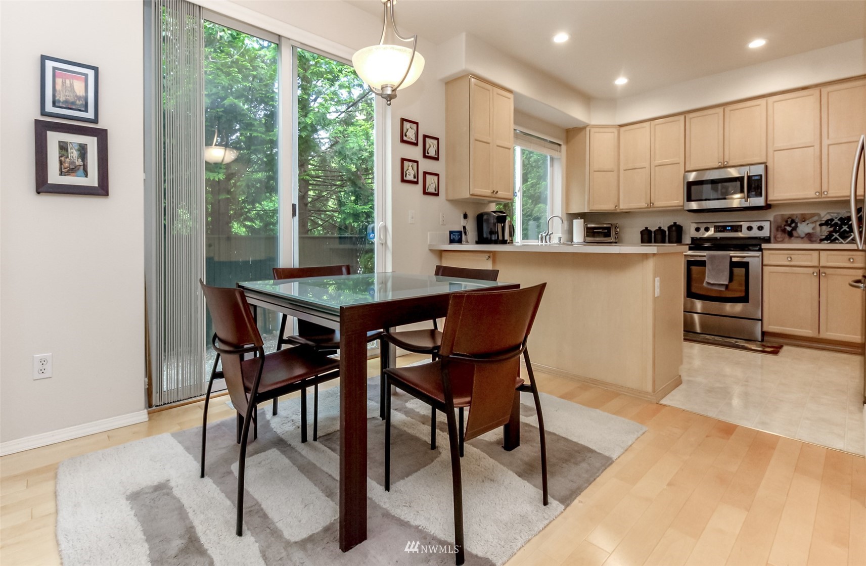 4632 Northeast 5th Court Renton, WA 98059 - Photo 8 of 23 a kitchen with stainless steel appliances kitchen island granite countertop a stove a refrigerator a microwave oven with a dining table and chairs