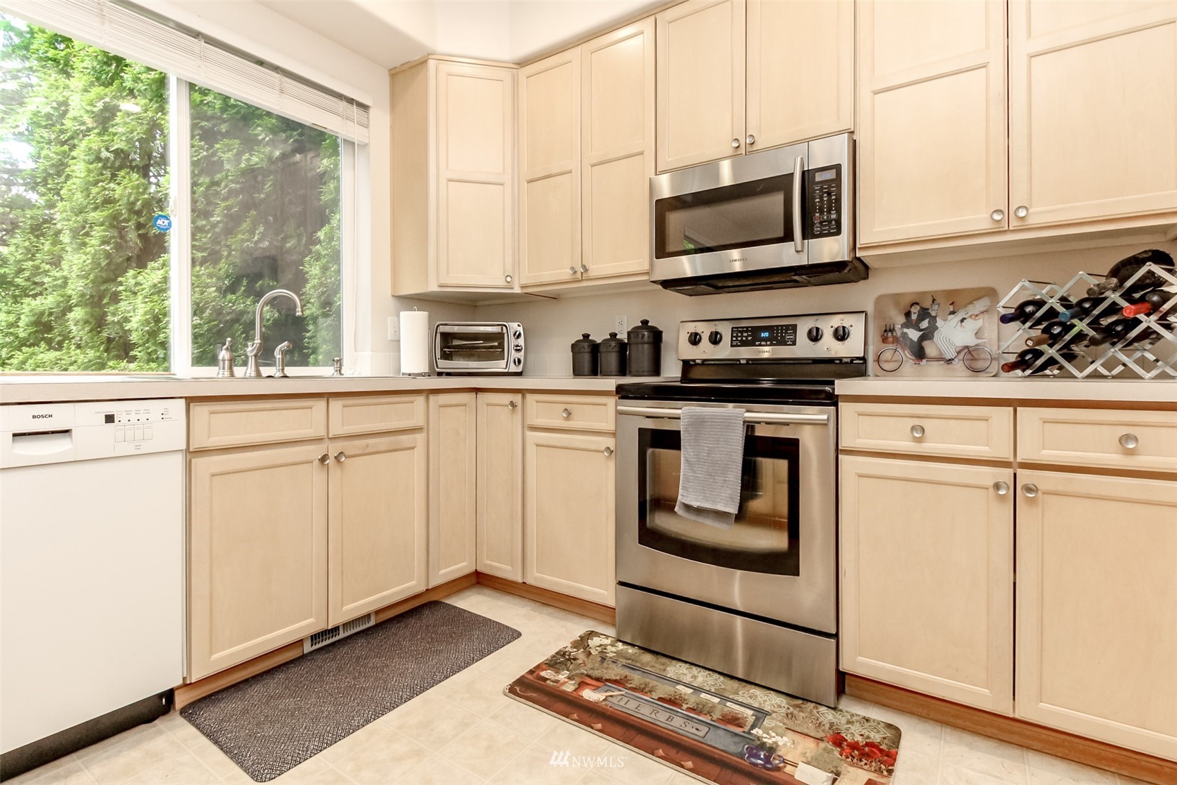 4632 Northeast 5th Court Renton, WA 98059 - Photo 10 of 23 a kitchen with stainless steel appliances granite countertop a stove a sink and white cabinets