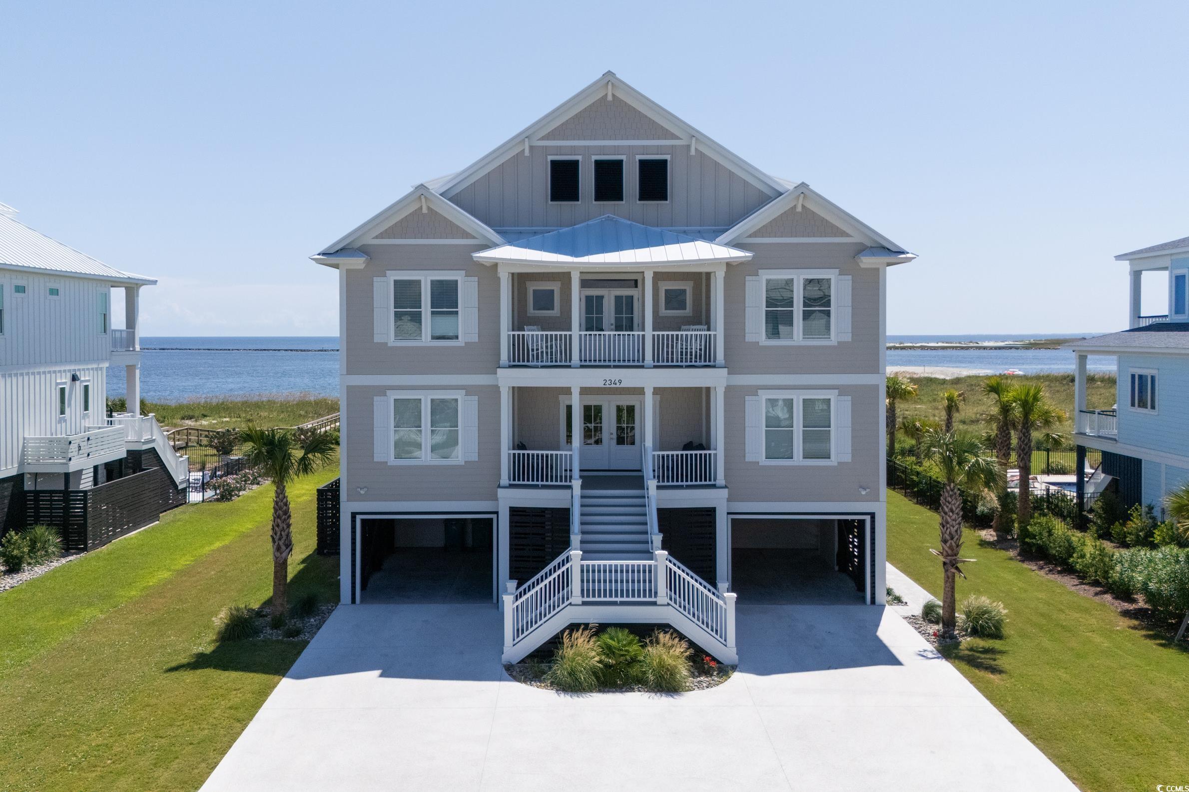 Beach home featuring stairway, an attached garage, french doors, and a water view