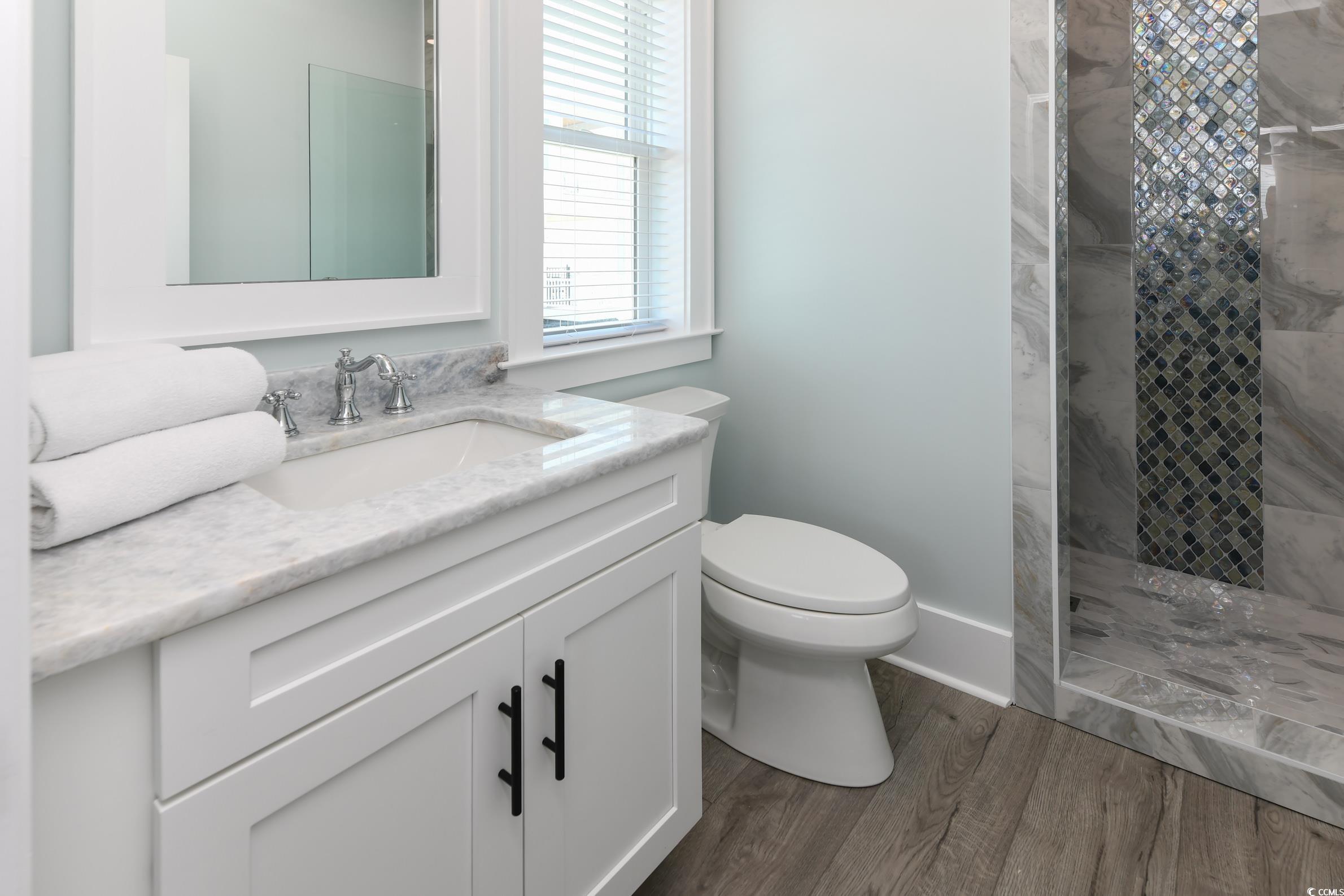 2349 South Waccamaw Drive Murrells Inlet, SC 29576 - Photo 21 of 39 Full bath with a tile shower, wood finished floors, toilet, and vanity