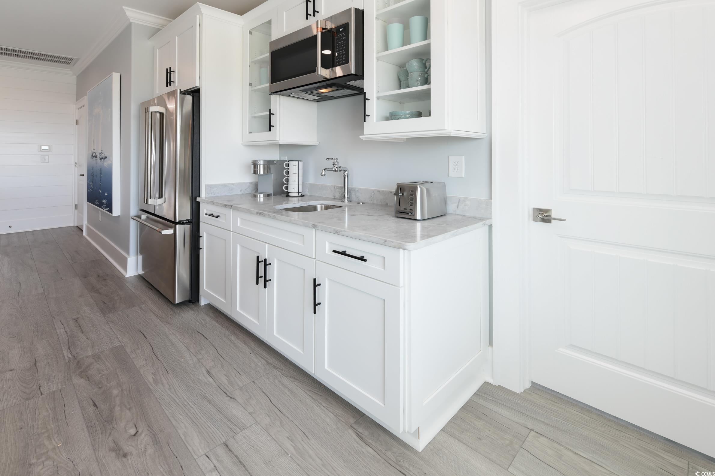 2349 South Waccamaw Drive Murrells Inlet, SC 29576 - Photo 27 of 39 Kitchen featuring a sink, light stone countertops, appliances with stainless steel finishes, glass insert cabinets, and visible vents