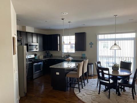 2847 Henley Lane Naperville, IL 60540 - Photo 8 of 9 a kitchen with stainless steel appliances granite countertop a stove a refrigerator a sink dishwasher a dining table and chairs with wooden floor
