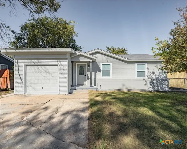 a front view of a house with a garden and yard