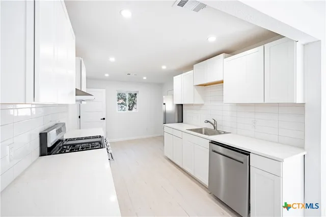 a kitchen with a sink stove and cabinets