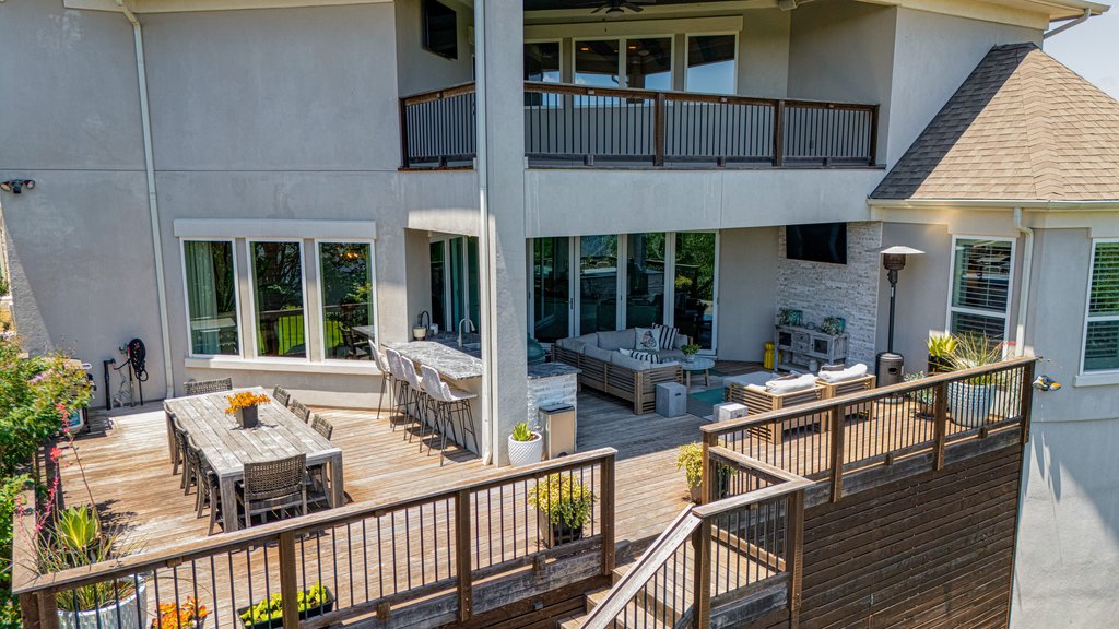 203 Lodestone Lane Austin, TX 78738 - Photo 7 of 40 Multi-level wood deck featuring an outdoor dining area, a covered lounge space, and a lower-level entertaining zone