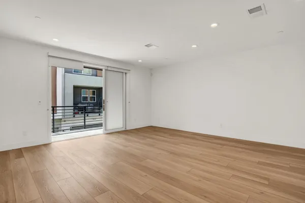 a view of a kitchen with wooden floor and electronic appliances