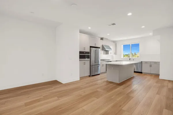 a kitchen with stainless steel appliances a sink stove and refrigerator