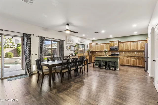 an empty room with wooden floor and a kitchen