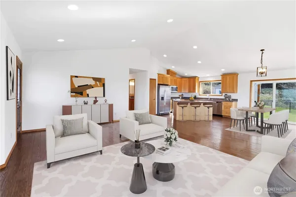 a living room with furniture and a dining table with kitchen view