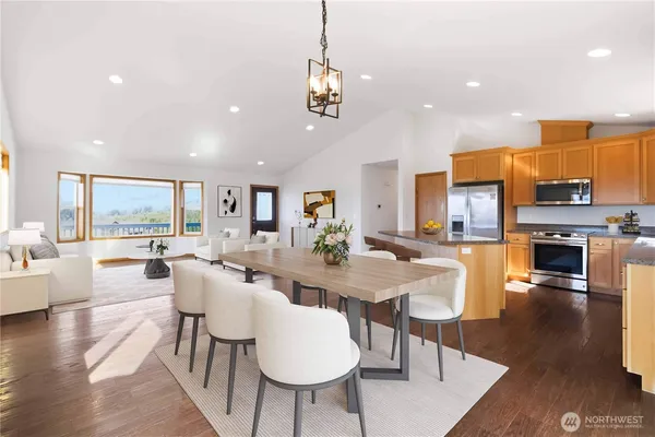a view of a dining room and livingroom with furniture wooden floor a chandelier