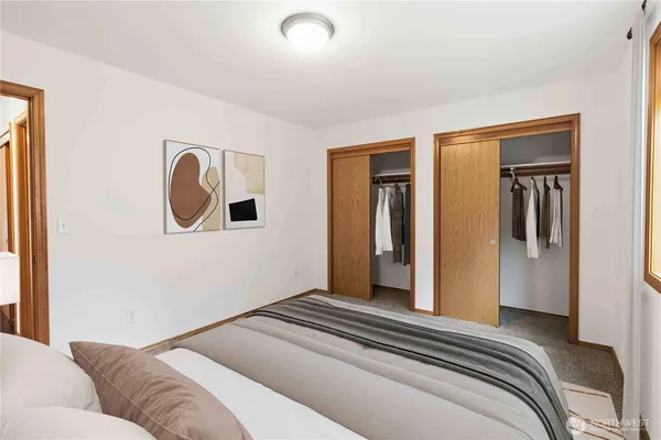a bedroom with a bed and a painting on the wall