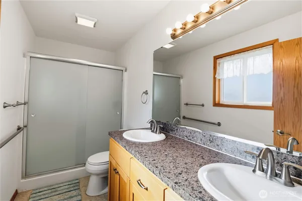 a bathroom with a granite countertop sink toilet and shower