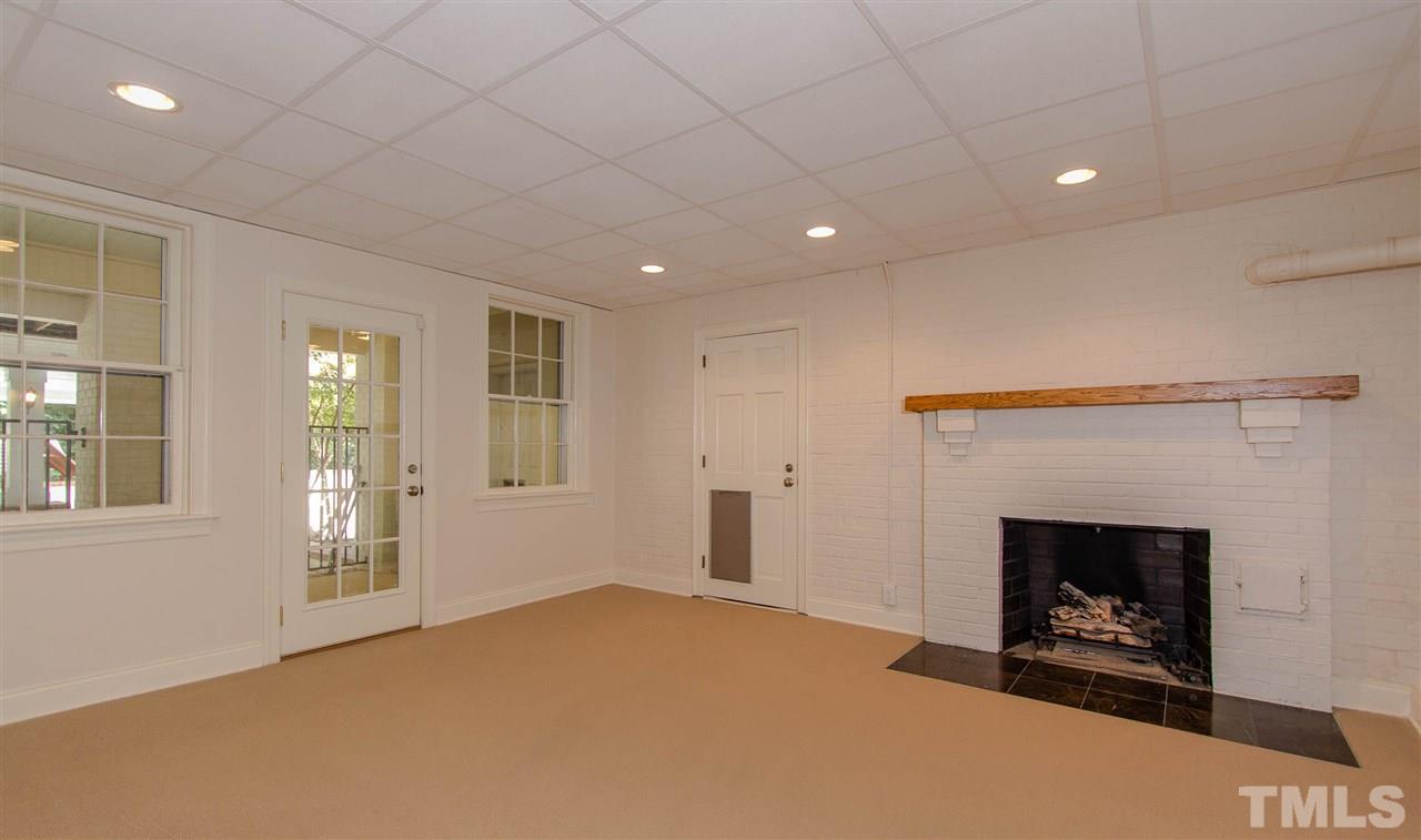 2726 Cambridge Road Raleigh, NC 27608 - Photo 22 of 25 a view of an empty room with a fireplace and a window
