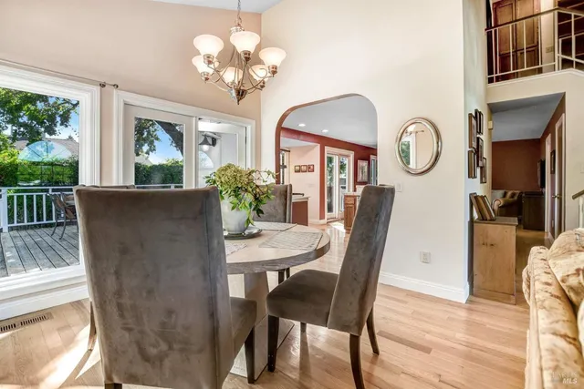 a view of a dining room with furniture a chandelier and wooden floor