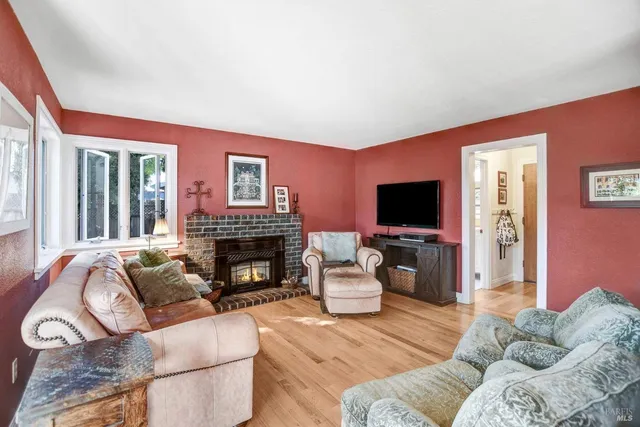 a living room with furniture a fireplace and a flat screen tv