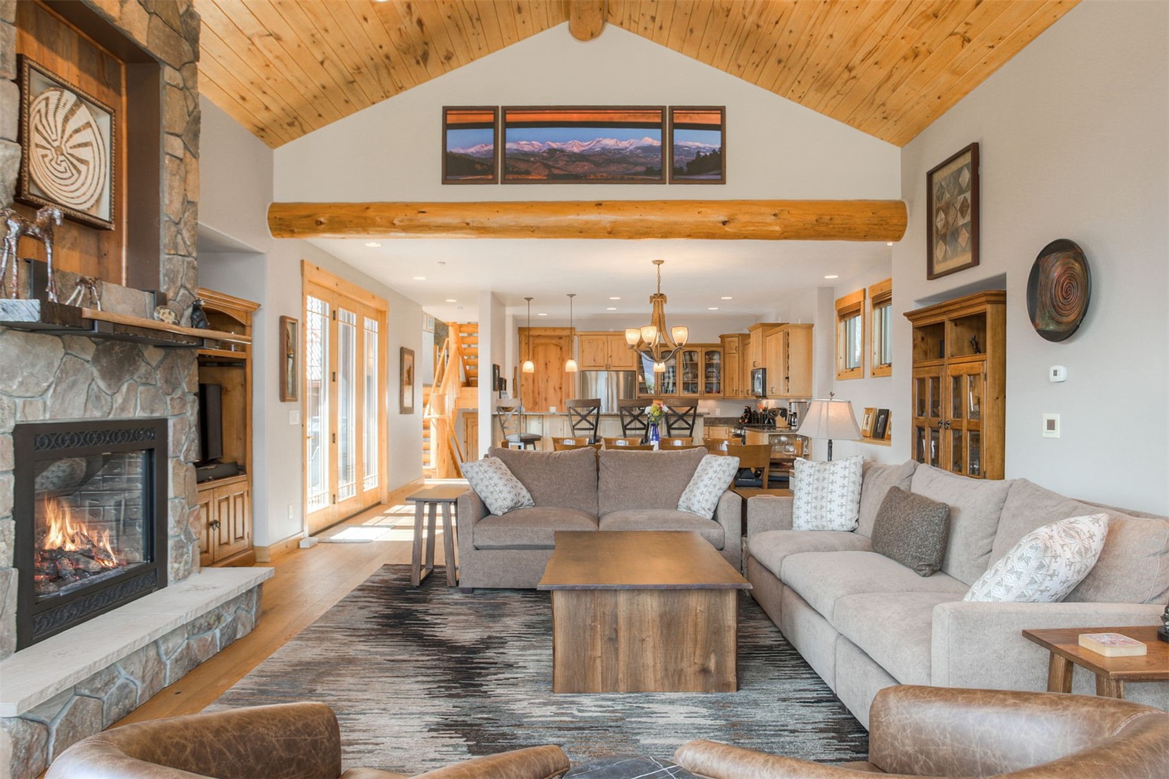727 Willowbrook Road Silverthorne, CO 80498 - Photo 6 of 47 Living room with a stone fireplace, wood finished floors, a high wood ceiling, and suspended lighting