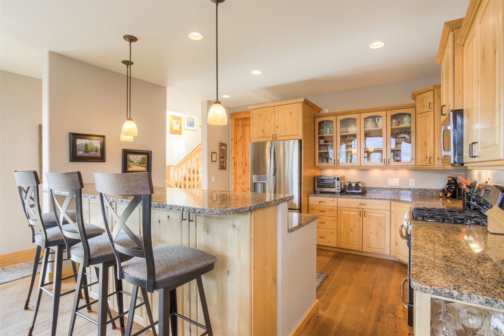 727 Willowbrook Road Silverthorne, CO 80498 - Photo 8 of 47 Kitchen with glass fronted cabinets, light wood finish cabinets, stainless steel appliances, dark wood-style floors, and dark stone counters