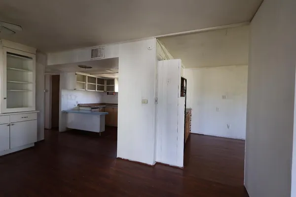 a view of a big room with wooden floor and a kitchen