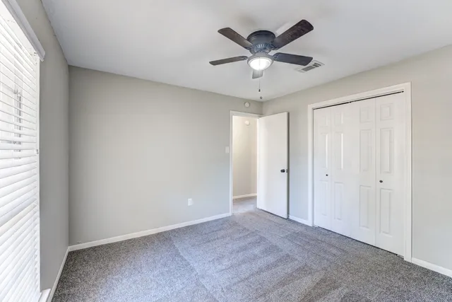 a view of a big room with wooden floor and windows in a room