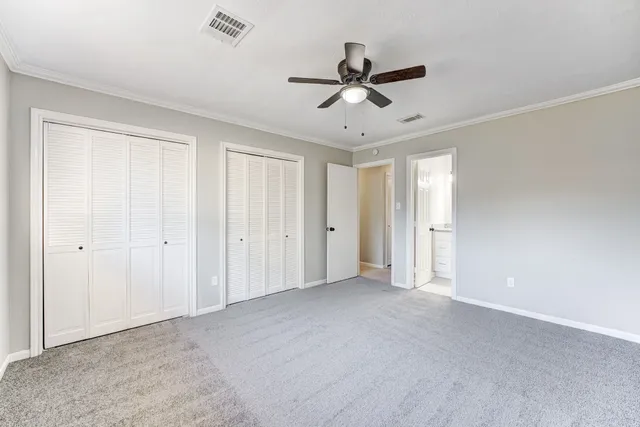 a view of an empty room and chandelier fan