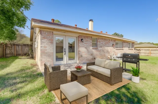 a view of a patio with couches table and chairs with wooden fence
