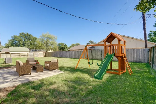 a view of backyard with a slide and potted plants