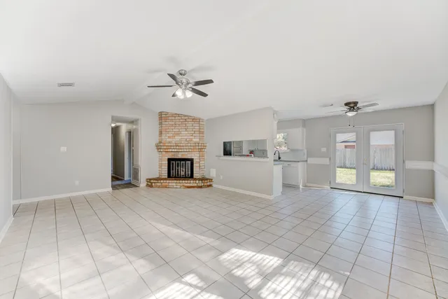 a view of an empty room with a fireplace and a window